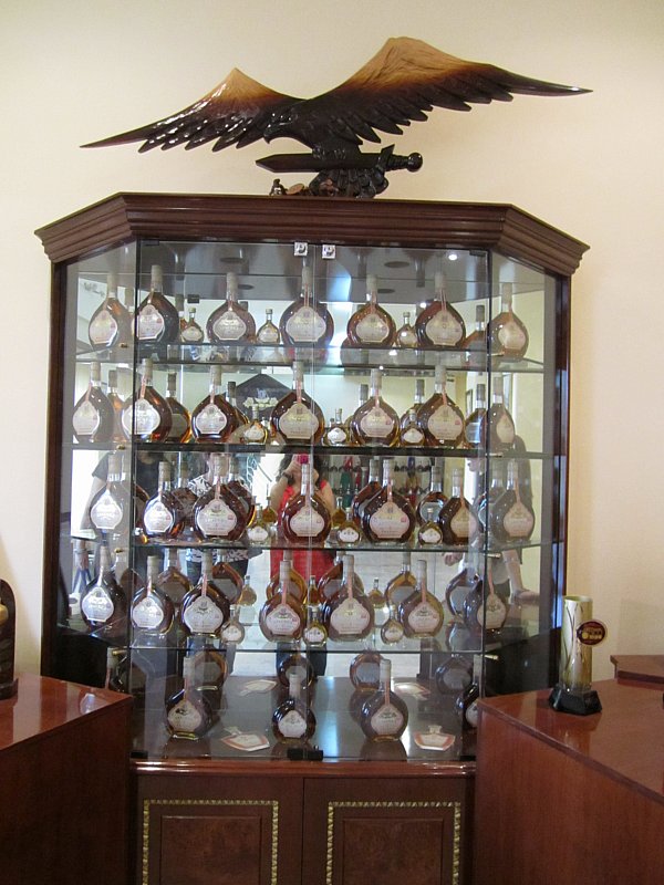 a glass enclosed display filled with bottles of Armenian brandy