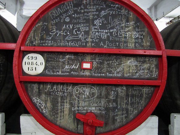 an alcohol barrel with lots of chalk writing on its surface