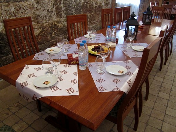 A wooden dining room table topped with plates and glasses