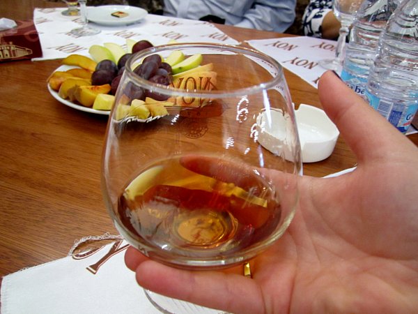 a closeup of a glass of brandy in someone\'s hand