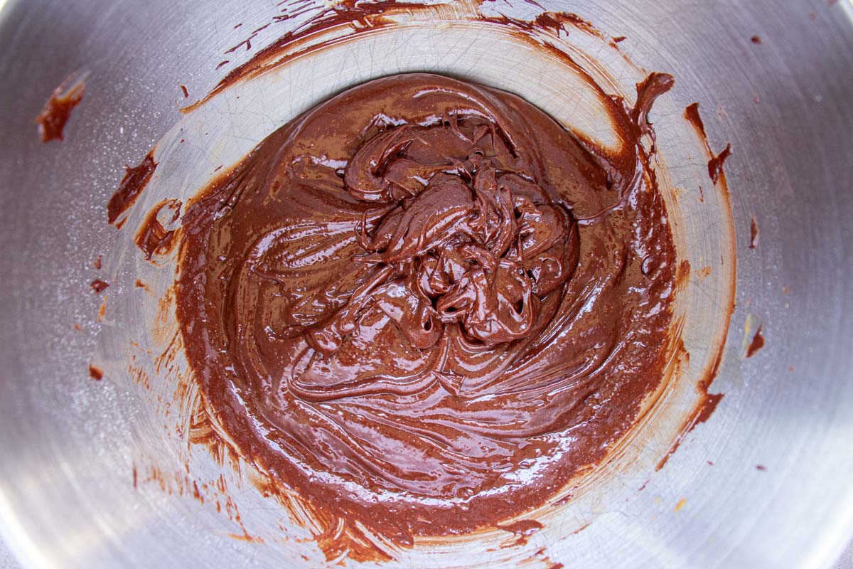 A thick chocolate batter in a metal mixing bowl.