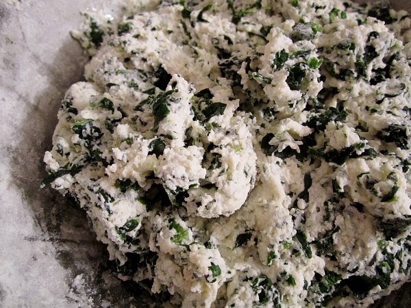 a mixture of ricotta cheese and spinach in a metal bowl