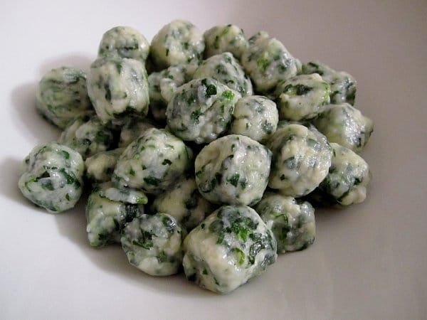 spinach and ricotta gnudi dumplings on a white plate