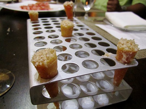 small cones filled with food arranged in a tray with holes in it