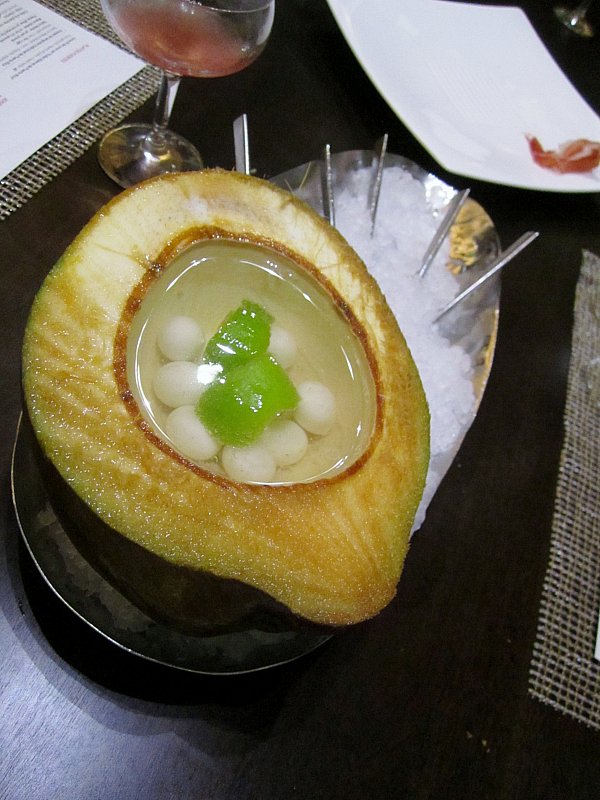 a halved fresh coconut filled with liquid and little white balls