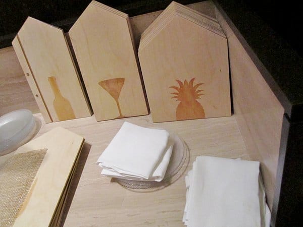 wooden menu covers shaped like houses with burnished images on them