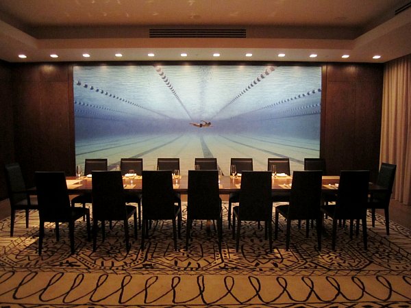 a long dining room table lined with black chairs