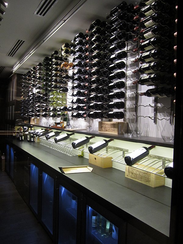 a wall covered with rows of bottles of wine