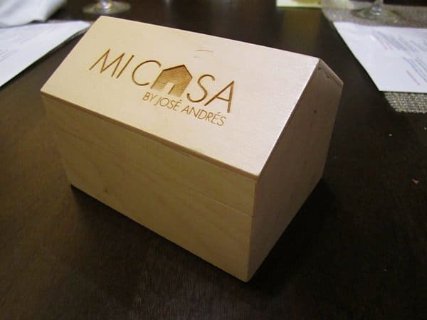 A wooden box on a table that says Mi Casa by Jose Andres