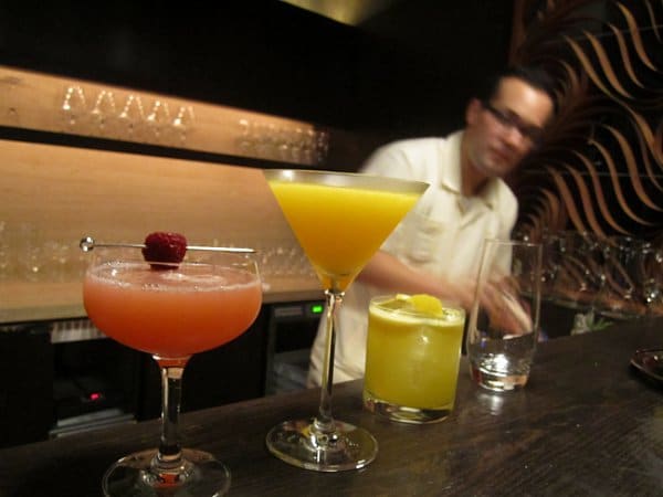 a variety of drinks lining a bar in a restaurant