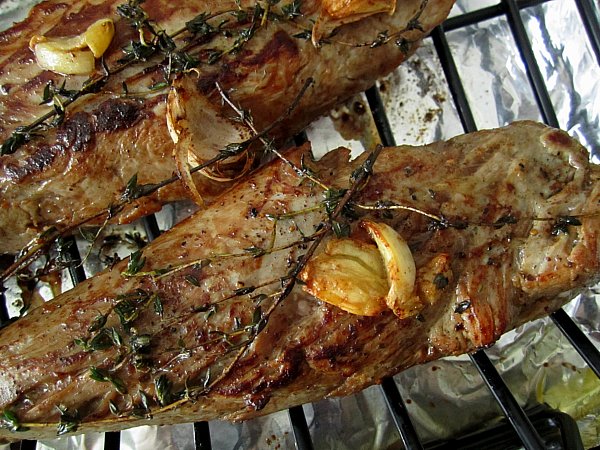 closeup of two roasted pork tenderloins on a roasting rack