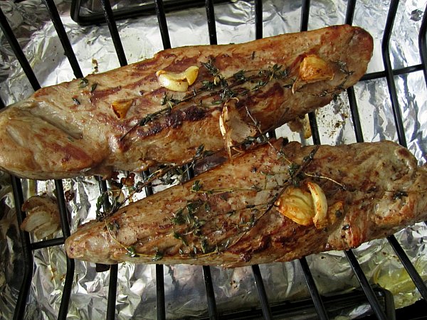 two roasted pork tenderloins on a roasting rack