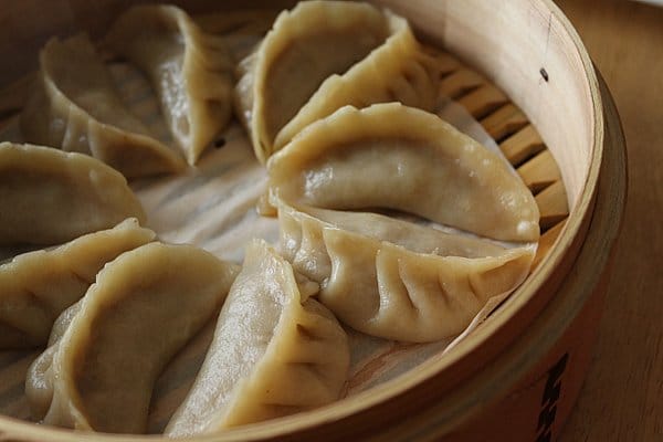 closeup of cooked dumplings in a bamboo steamer basket