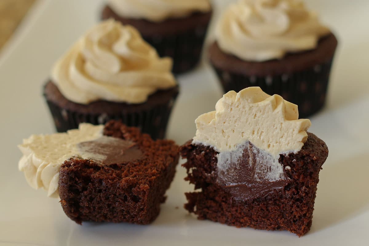 Cross section of chocolate Guinness cupcake showing off the chocolate filling inside.