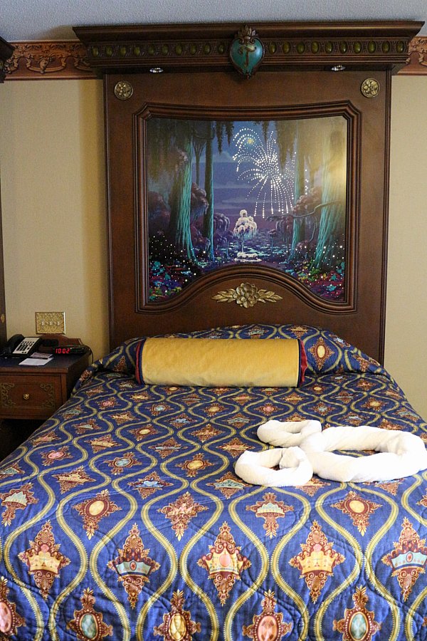 A double bed with a dark blue bedspread in a hotel room