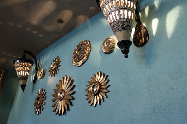 round metal decorations and lights on a blue wall