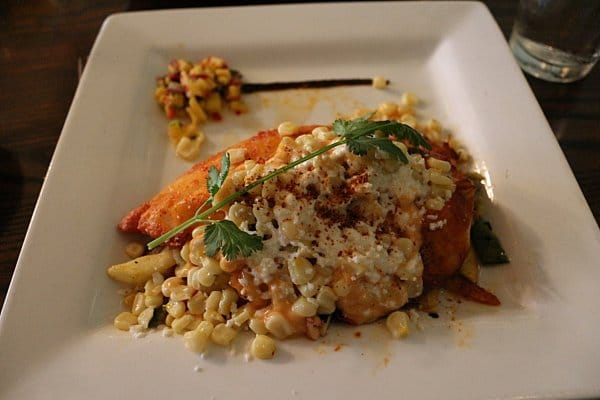 fish served with corn on a white plate