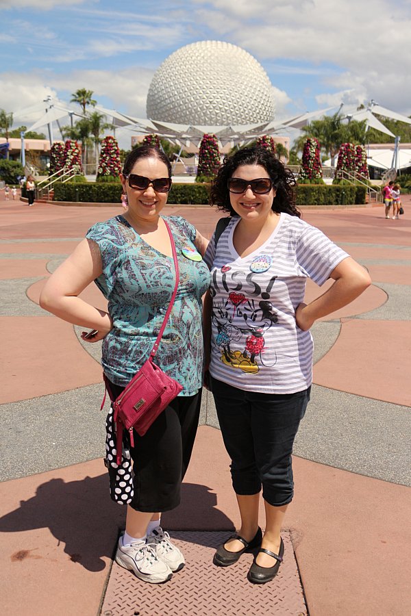 two women posing in front of Spaceship Earth at Epcot