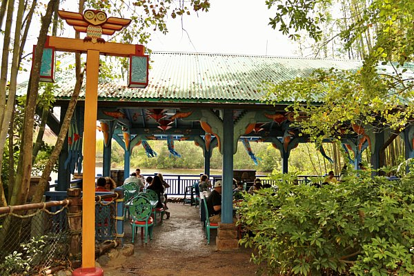 an open air covered dining area surrounded by trees