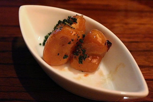 two small orange bites of food in a white dish