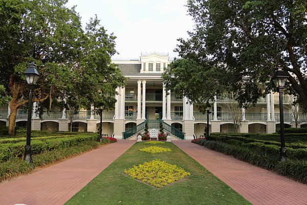 A plantation style building with a garden in front