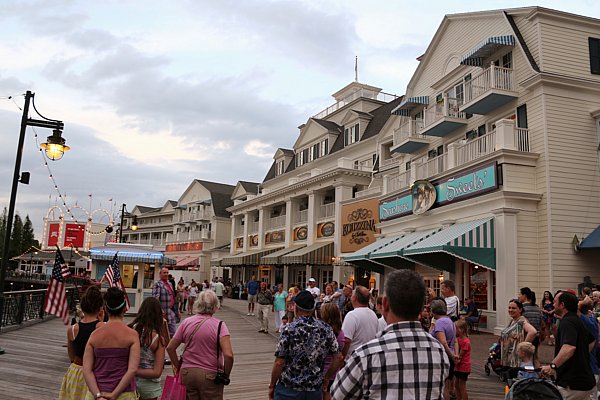 A group of people on a boardwalk lined with shops