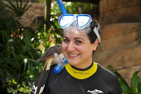 a woman with a snorkel on her head and a bird on her shoulder