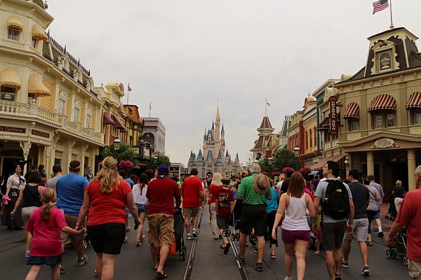 A group of people walking down Main Street USA at Disney\'s Magic Kingdom
