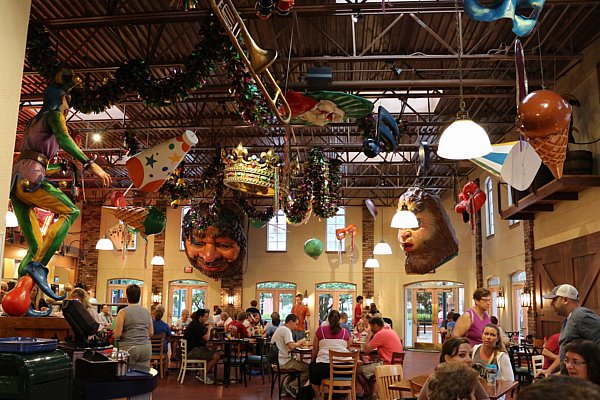 people eating in a large dining room with giant objects hanging from the ceiling