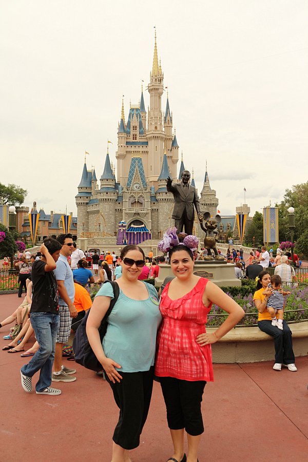 two women posing in front of Cinderella\'s Castle