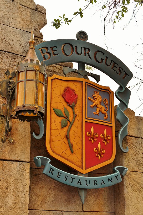 a family shield with a rose and lion that says Be Our Guest Restaurant