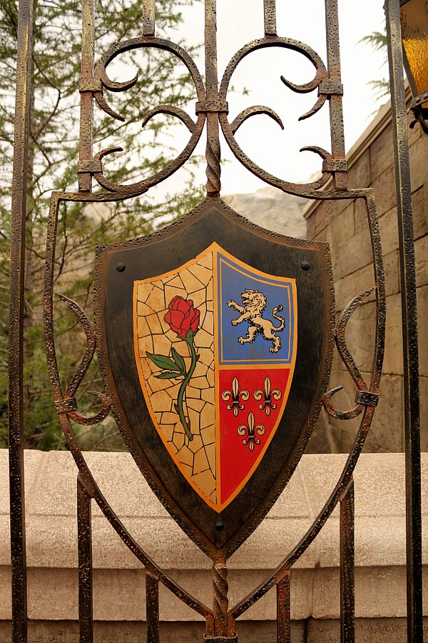 a family shield with a rose and lion on the grates of a wrought iron fence