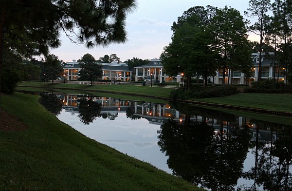 A river at dawn with plantation style buildings in the background