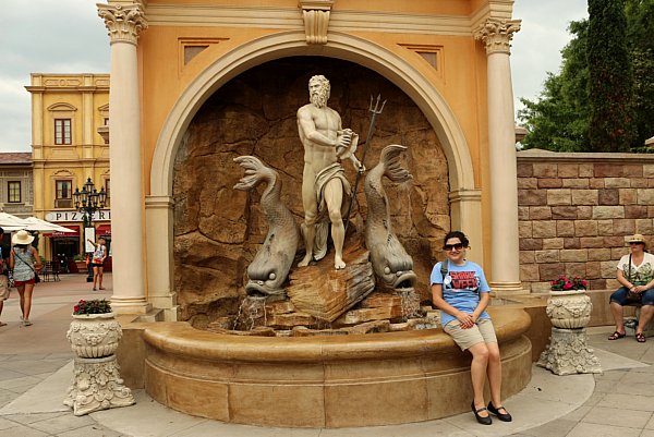 a woman posing next to a fountain