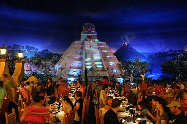 people dining in a restaurant with a Mexican pyramid in the background