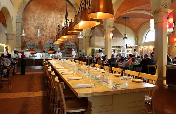 a very long dining table with chairs on either side