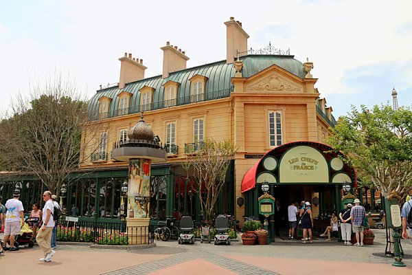 A group of people walking in front of Les Chefs de France restaurant in Epcot