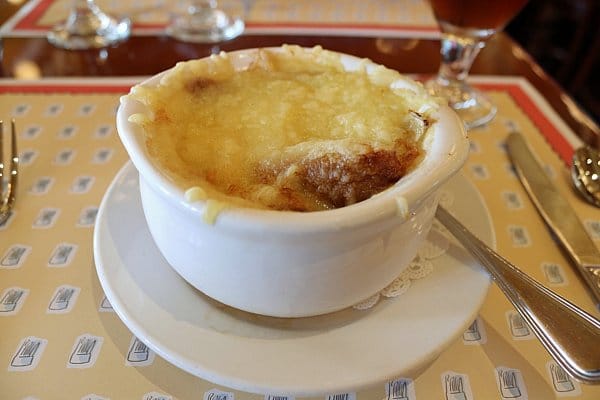 French onion soup topped with melted cheese in a white bowl