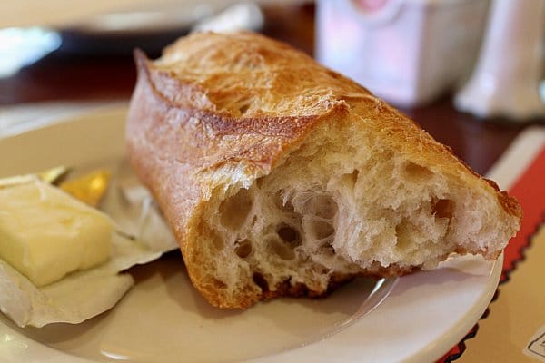 closeup of a cross section of a piece of baguette on a white plate