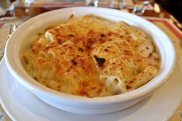 A closeup of baked pasta with a crusty browned topping in a white dish