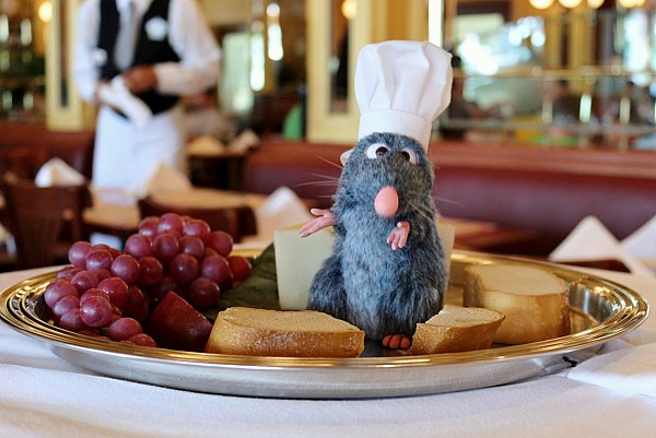 Remy from Ratatouille standing on top of a cheese cart