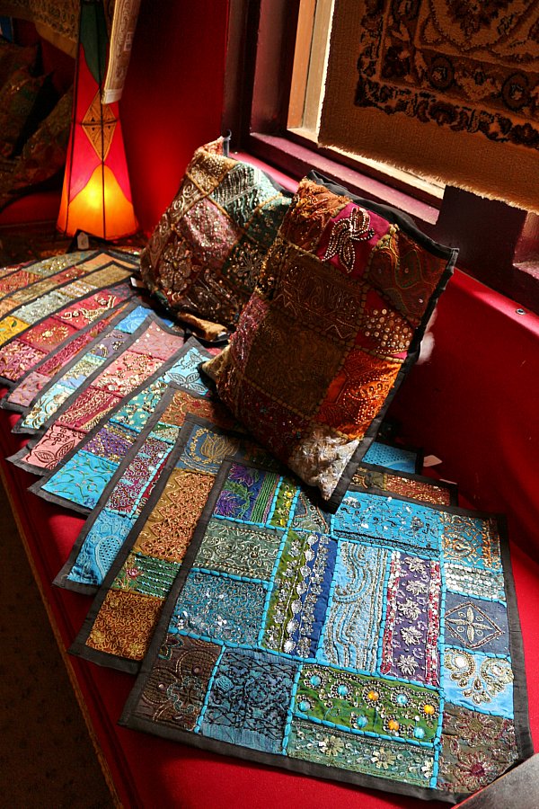 colorful beaded fabrics fanned out on a red surface