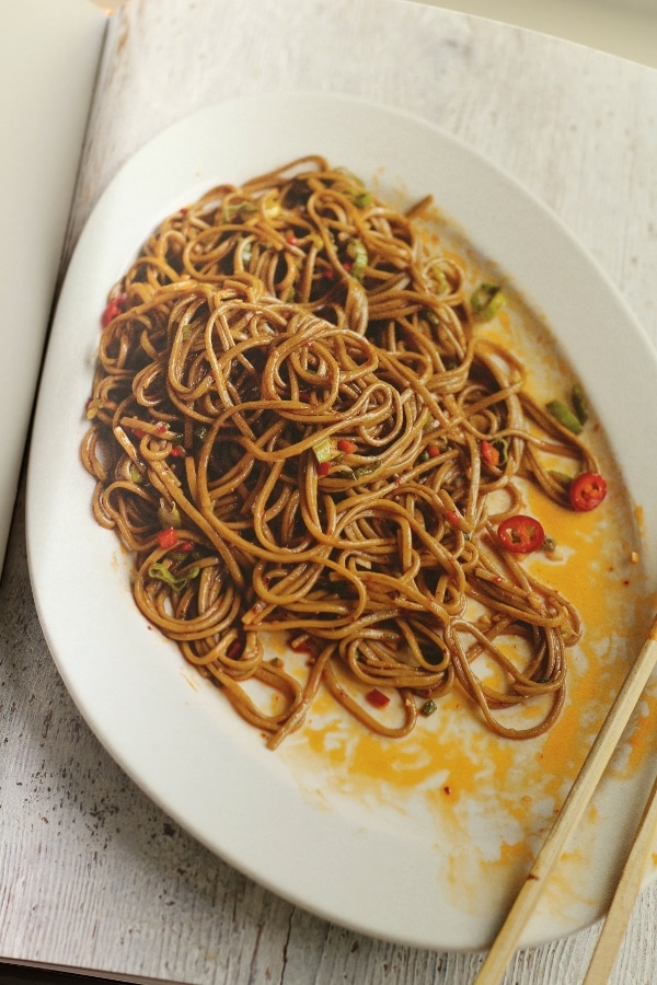 overhead view of a platter of brown noodles with chiles