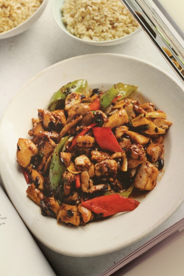 A plate of stir-fried chicken with red and green peppers