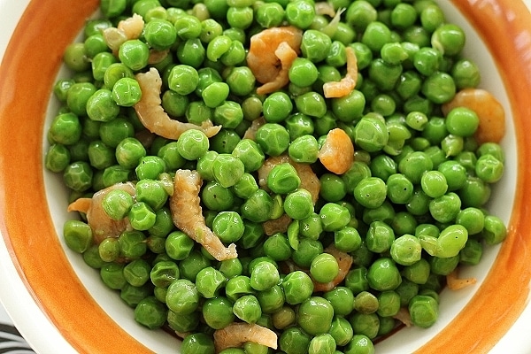 overhead view of a bowl of cooked peas with dried shrimp