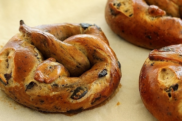 Big, puffy, homemade soft pretzel with olives