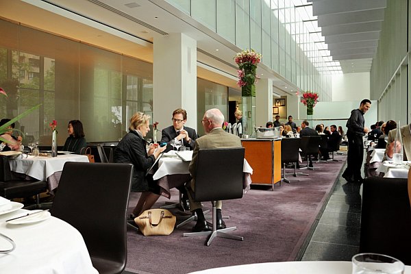 A group of people sitting in a modern looking restaurant dining room