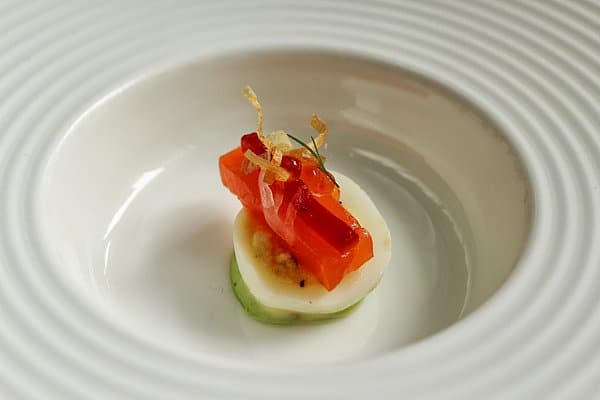 an artfully plated small bite of food on a white plate