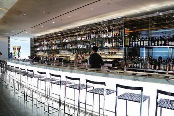 a restaurant bar with a white front and tall bar stools