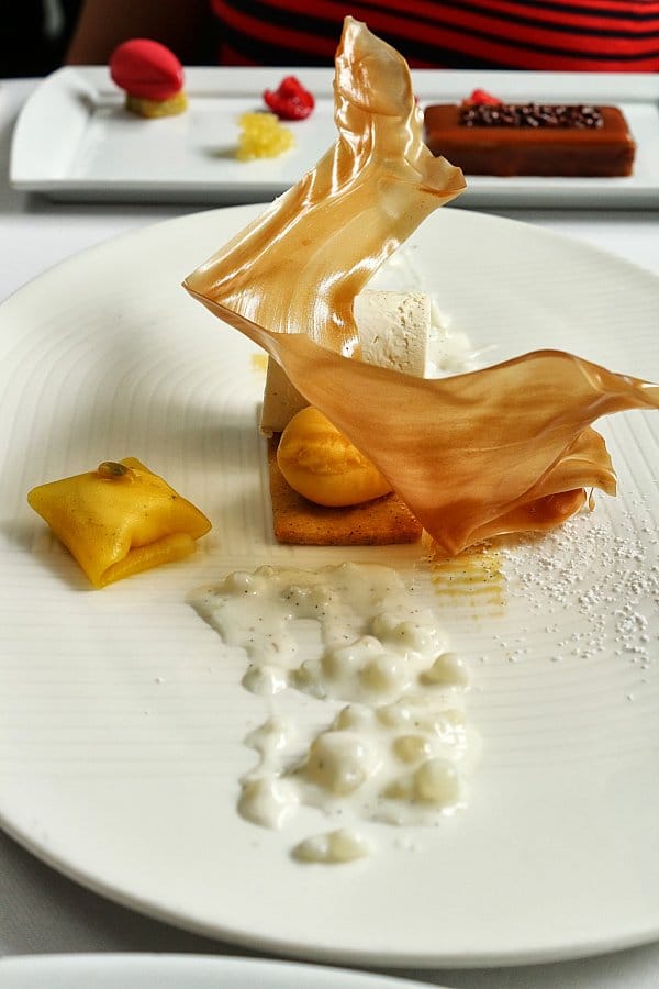 a plate of dessert with a sugar decoration on top